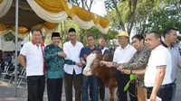 Penyerahan hewan kurban oleh Wakil Bupati Gresik Mohammad Qosim kepada masyarakat gunung di tepi pantai Gresik (Foto: Liputan6.com/Dian Kurniawan)