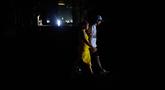 Orang-orang menyeberang jalan saat pemadaman listrik di Havana, Kuba, Rabu 4 Maret 2026. Pemadaman listrik besar melanda dua pertiga wilayah Kuba, termasuk ibu kota Havana. (AP Photo/Ramon Espinosa)