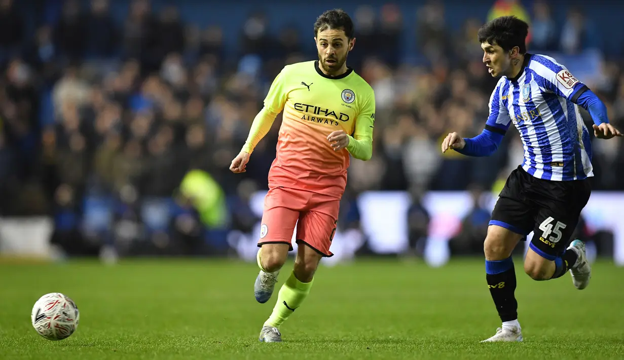 Gelandang Manchester City, Bernardo Silva berebut bola dengan pemain Sheffield Wednesday, Fernando Forestieri pada putaran kelima Piala FA di Hillsborough, Rabu (4/3/2020).Sempat kesulitan, Manchester City akhirnya menang tipis 1-0 atas Sheffield Wednesday lewat gol Sergio Aguero. (Paul ELLIS/AFP)