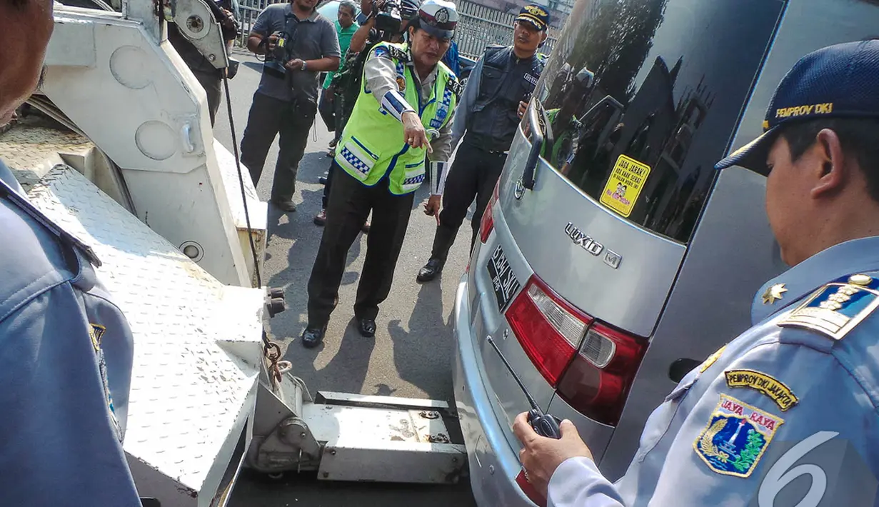 Petugas sedang bersiap-siap menderek mobil yang parkir sembarangan di kawasan Jatinegara, Jakarta, Senin (8/9/2014) (Liputan6.com/Faizal Fanani)