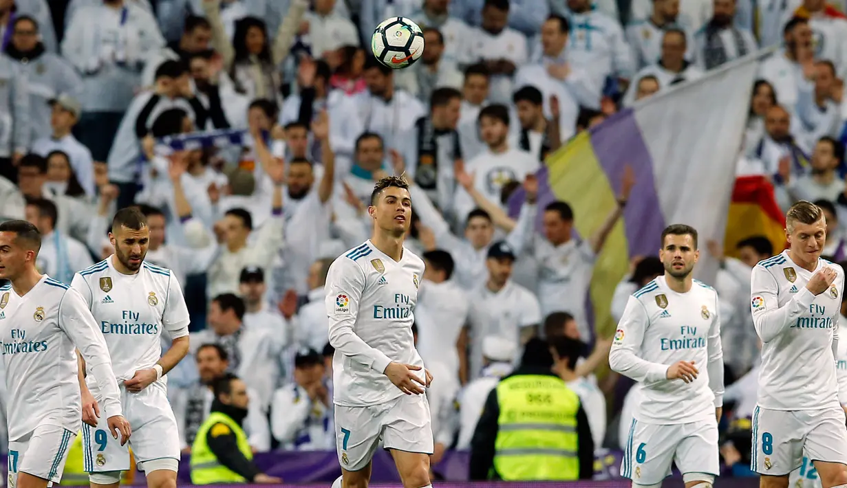 Striker Real Madrid Cristiano Ronaldo (tengah) melempar bola ke udara setelah membobol gawang Girona saat pertandingan La Liga Spanyol di stadion Santiago Bernabeu di Madrid (18/3). Real Madrid menang 6-3 atas Girona. (AP Photo / Paul White)