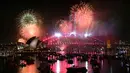 Cahaya kembang api menerangi langit di atas Jembatan Pelabuhan Sydney dan Gedung Opera Sydney, Australia, selama perayaan malam pergantian tahun, pada 1 Januari 2026. (Saeed KHAN/AFP)