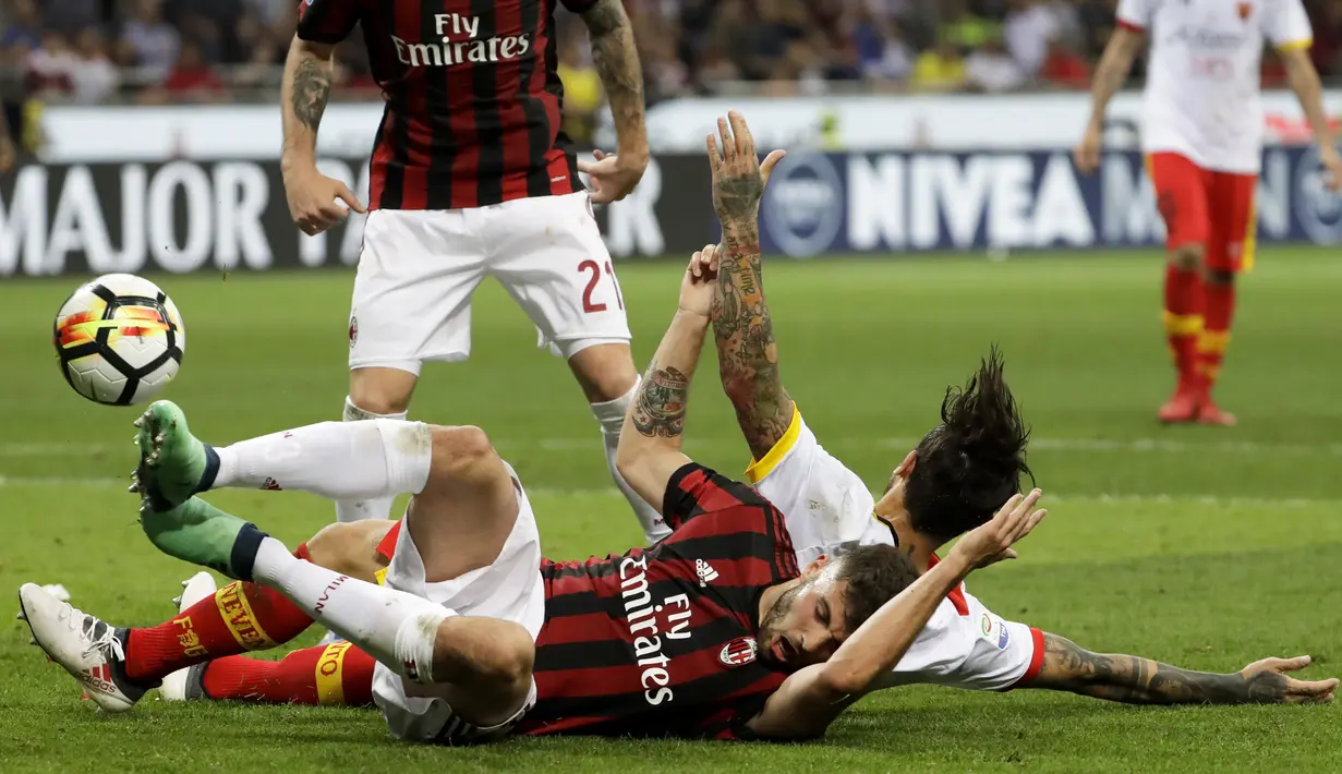 Pemain AC Milan, Patrick Cutronefront jatuh saat berebut bola dengan pemain Benevento, Nicolas Benito Viola pada laga Serie A di San Siro stadium, Milan, (21/4/2018). AC Milan kalah 0-1. (AP/Luca Bruno)