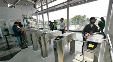 Penumpang tap tiket saat "Uji Coba Pelayanan Pengguna Jasa KRL" di Lantai Dua Stasiun Cakung, Jakarta, Selasa (9/10). BTPWJB Kemenhub telah merampungkan modernisasi Stasiun Cakung. (Liputan6.com/Herman Zakharia)