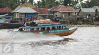 Warga menggunakan perahu motor sebagai transportasi alternatif dari Kota Palembang menuju Ogan Komering Ilir (OKI) di Sungai Baung, Sumsel, (24/30). Dari Kota Palembang menuju OKI hanya menghabiskan waktu 2 jam. (Liputan6.com/Gempur M Surya)