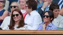 Duchess of Cambridge Kate Middleton dan Duchess of Sussex Meghan Markle tersenyum saat menyaksikan pertandingan Serena Williams dan Angelique Kerber di kejuaraan  tenis Wimbledon di London, Inggris, (14/7). (AP Photo/Andrew Couldridge)