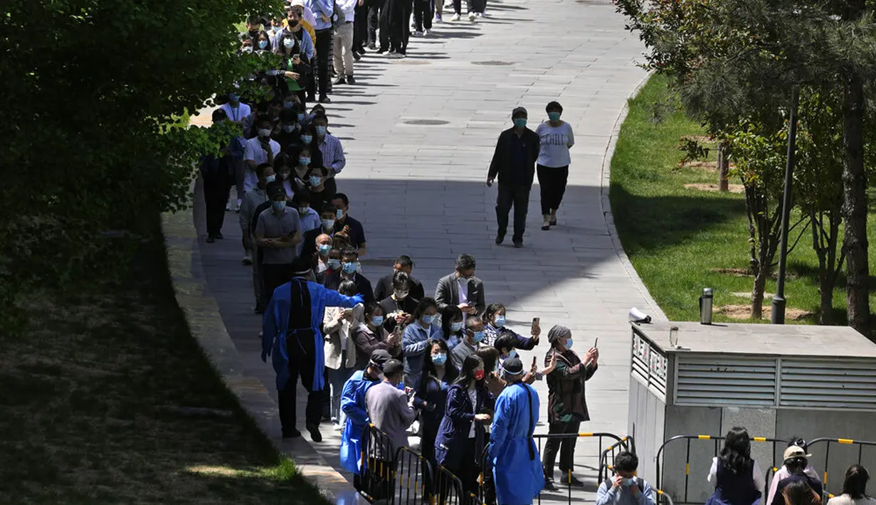 <p>Warga berbaris untuk menjalani pengujian massal COVID-19 dekat tenda yang didirikan di sebuah plaza di Distrik Haidian, Beijing, China, Selasa (26/4/2022). Beijing memberlakukan pengujian massal dan menutup akses ke lingkungan karena berupaya menahan wabah COVID-19 baru. (AP Photo/Ng Han Guan)</p>