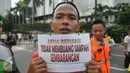 Seorang warga menunjukkan tulisan "Saya Berjanji Tidak Membuang Sampah Sembarangan" saat menjalani sidang karena tertangkap membuang sampah sembarangan di kawasan Bundaran HI, Jakarta, Minggu (24/4).(Liputan6.com/ Gempur M Surya)