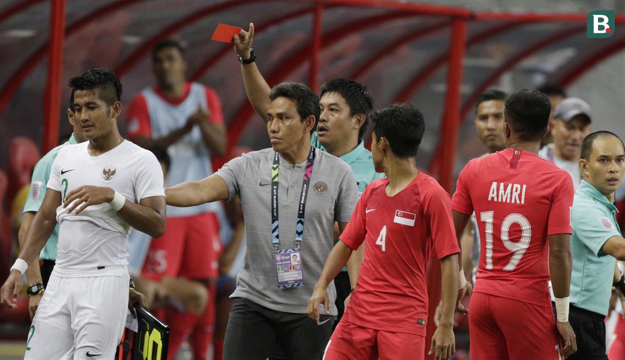 Wasit memberikan kartu merah kepada bek Timnas Indonesia, Putu Gede, saat melawan Singapura pada laga Piala AFF di Stadion Nasional, Singapura, Jumat (9/11). Singapura menang 1-0 atas Indonesia. (Bola.com/M. Iqbal Ichsan)