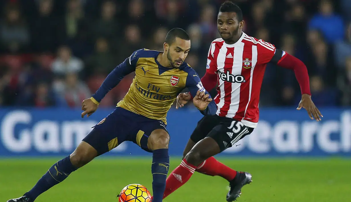 Gelandang serang Arsenal, Theo Walcott, berusaha melewati hadangan pemain Southampton, Cuco Martina, pada laga Premier League. The Gunners gagal melanjutkan tren positif mereka. (Reuters/Eddie Keogh)