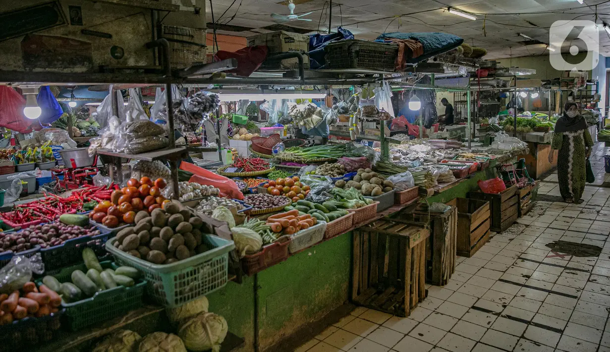 Pengunjung berjalan melewati kios pedagang sayur di Pasar Pondok Labu, Jakarta, Rabu (10/2/2021). Satu pedagang terpapar Covid-19, meski begitu pengelola Pasar Pondok Labu tetap melanjutkan operasional pasar sambil melakukan tracing dan tracking pada para pedagang. (Liputan6.com/Faizal Fanani)