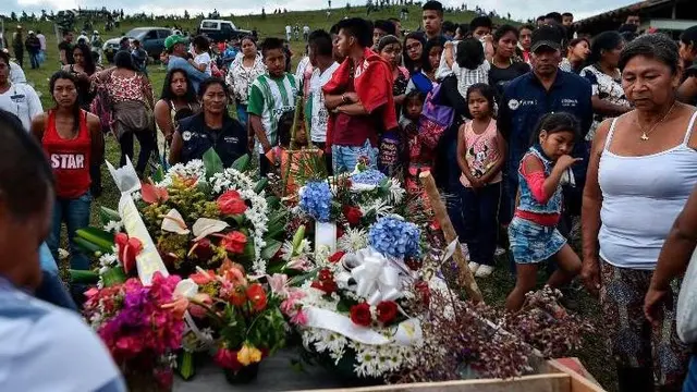 Para kerabat berduka atas kematian seorang pemimpin komunitas yang terbunuh di daerah Caloto, Kolombia, pada Juli 2018.
