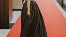 Seperti saat datang di AMI Awards 2022, ia tampil glamor mengenakan gaun hitam dengan aksen payet silver. [Instagram/rinni_w].
