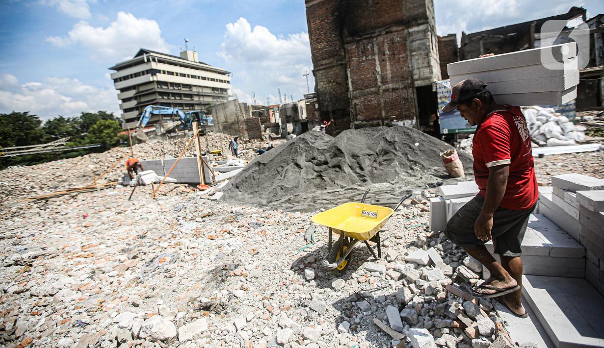 Pekerja menyelesaikan pembangunan Kampung Gembira Gembrong, Jakarta, Senin (4/7/2022). Pemprov DKI Jakarta telah memulai proses revitalisasi permukiman korban kebakaran Pasar Gembrong di RW 001 yang akan diberi nama Kampung Gembira Gembrong. (Liputan6.com/Faizal Fanani)