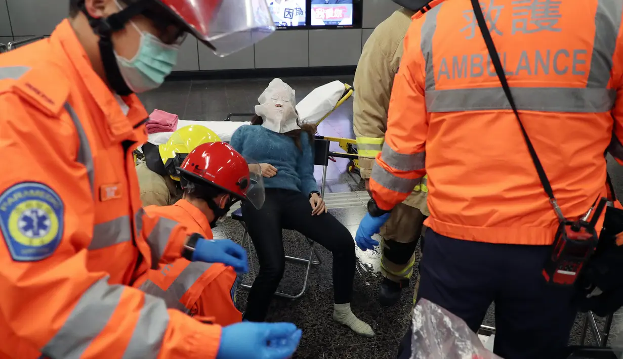 Sejumlah petugas medis mengevakuasi korban kebakaran di Stasiun Tsim Sha Tsui, Hong Kong (10/2). Akibat insiden ini, Stasiun Tsim Sha Tsui ditutup untuk sementara dan terdapat gangguan layanan di Jalur Tsuen Wan. (Handout / Apple Daily / AFP)