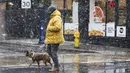 Seorang pria yang mengenakan masker berjalan bersama anjingnya di sebuah jalan di Toronto, Kanada, pada 22 November 2020. Hingga Minggu (22/11) malam, Kanada melaporkan total 330.503 kasus dan 11.455 kematian karena COVID-19, menurut CTV. (Xinhua/Zou Zheng)