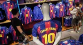 Pengunjung memilih jersey baru bernomor punggung 10 dari penyerang Barcelona asal Spanyol, Lamine Yamal di toko resmi FCB di Barcelona. (AFP/Manaure Quintero)