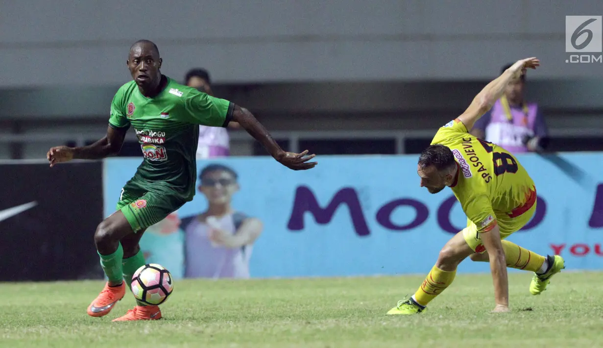 Pemain baru PS TNI, Franklin Anzite Touadere (kiri) mengecoh pemain Bhayangkara FC, Ilija Spasojevic saat lanjutan Liga 1 Indonesia di Stadion Pakansari, Kab Bogor, Minggu (3/9). PS TNI kalah 0-1. (Liputan6.com/Helmi Fithriansyah)