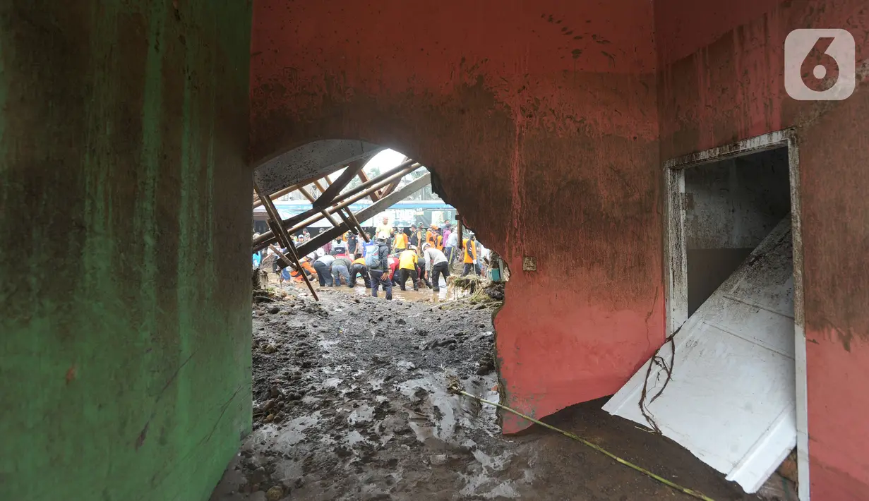 Tim SAR gabungan TNI, Polri, dan relawan membersihkan material longsor usai banjir bandang menerjang Kampung Cibuntu, Desa Pasawahan, Kecamatan Cicurug, Sukabumi, Selasa (22/9/2020). Banjir mengakibatkan puluhan bangunan rusak berat, 12 rumah hanyut, dan dua korban hilang. (merdeka.com/Arie Basuki)