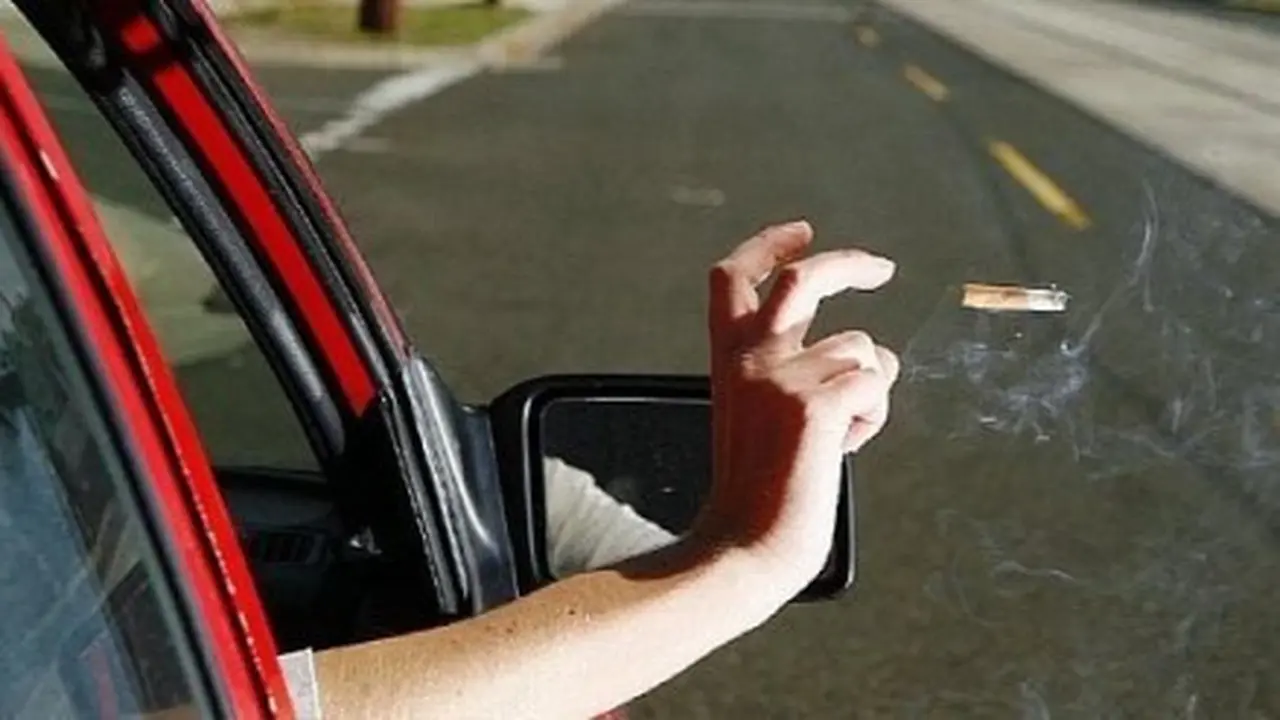 Pengendara mobil membuang putung rokok dari dalam mobil