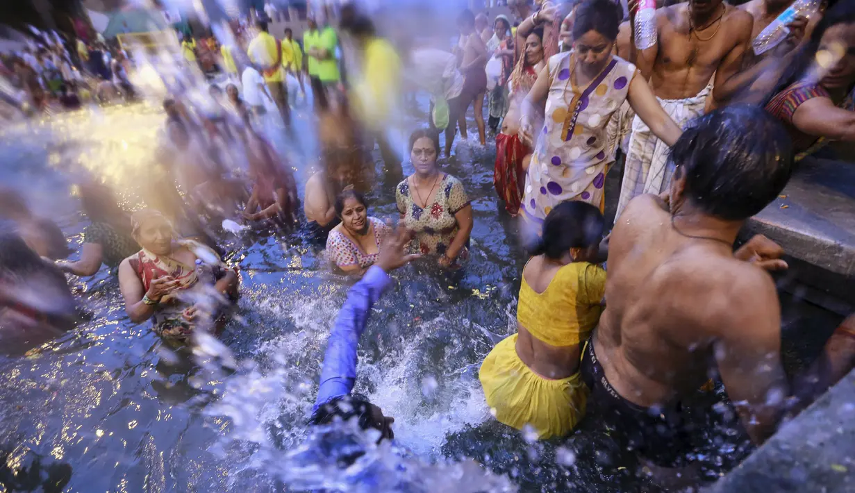 Umat Hindu berdoa sambil berdiri di sungai Godavari selama Festival Pitcher di Nashik, India, (28/8/2015). Ratusan ribu umat Hindu mengambil bagian dalam perayaan keagamaan yang diadakan setiap 12 tahun sekali. (REUTERS/Danish Siddiqui)