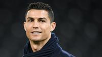 Penyerang Juventus, Cristiano Ronaldo tersenyum saat memeriksa lapangan di Stade de Suisse di Bern (11/12). Ronaldo tampil keren menggenakan setelan jas dengan syal di lehernya saat mengecek markas Young Boys. (AFP Photo/Fabrice Coffrini)