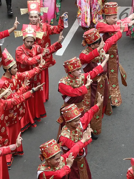 Peserta memakai kostum tradisional saat meramaikan pawai obor Asian Para Games 2018 di Jakarta, Minggu (30/9). Pawai obor dimulai dari Balai Kota DKI Jakarta dan berakhir di Gedung Kementerian Pemuda dan Olahraga. (Liputan6.com/Herman Zakahria)