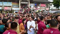 Presiden Joko Widodo (tengah) berswafoto dengan warga saat meninjau rencana revitalisasi Pasar Sukawati di Gianyar, Bali, Jumat (14/6/2019). Jokowi yang ditemani Ibu Negara Iriana mengawali kunjungan kerja ke Bali dengan meninjau Pasar Sukawati. (Liputan6.com/Pool/Biro Pers Setpres)