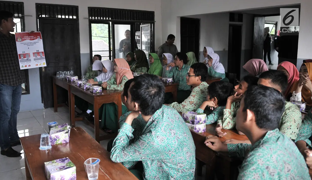 Anggota KPUD Bekasi mengajarkan pemilih pemula penyandang disabilitas mencoblos surat suara saat sosialisasi Pemilu 2019 di SLB Al Gaffar Guchany, Bekasi, Rabu (20/2). (Merdeka.com/Iqbal Nugroho)