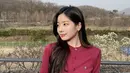 Dahyun Twice mengenakan cardigan merah yang dimasukan ke dalam celana denimnya. Gaya ini membuat Dahyun terlihat santai namun tetap rapi. Dok. Instagram @twicetagram