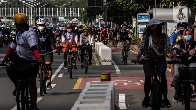 Warga bersepeda saat uji coba pembatas jalur sepeda permanen di kawasan Sudirman, Jakarta, Minggu (28/2/2021). Dalam uji coba tersebut terlihat masih banyak pesepeda yang melintas di luar jalur khusus yang telah disediakan. (Liputan6.com/Johan Tallo)