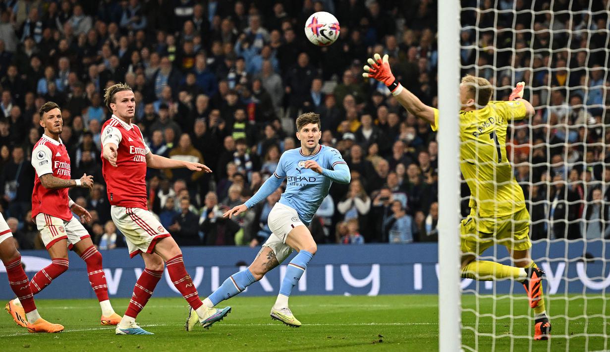 Pemain Manchester City, John Stones mencetak gol ke gawang Arsenal pada laga lanjutan Liga Inggris 2022/2023 di Etihad Stadium, Manchester, 26 April 2023. Kemenangan 4-1 Man City tersebut menjadi pukulan telak bagi Arsenal. Peluangnya merengkuh gelar juara Liga Inggris turun menjadi 10 persen setelah The Cityzens masih memiliki dua laga sisa. Ditambah lagi, beberapa pekan kemudian, Arsenal kalah dari Brighton dan membuatnya tergelincir dari puncak klasemen liga. (AFP/Oli Scarff)