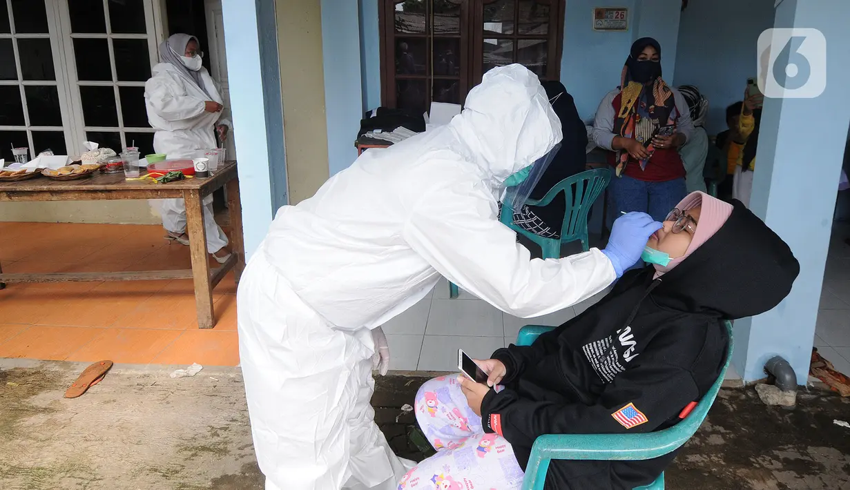 Petugas Puskesmas mendatangi warga di kawasan permukiman RT 04/ RW 02 Kelurahan Srengseng Sawah, Jagakarsa, Jakarta, Selasa (25/05/2021).  Satu RT di wilayah itu menerapkan lockdown skala mikro setelah 13 warga dikonfirmasi positif Covid-19. (merdeka.com/Arie Basuki)