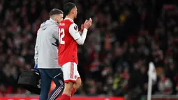 Pemain Arsenal, William Saliba berjalan meninggalkan lapangan setelah mengalami cedera pada alag 16 besar Liga Europa 2022/2023 melawan Sporting Lisbon di Emirates Stadium, London, 16 Maret 2023. Cedera yang dialami pemain asal Prancis ini memberi dampak besar terhadap perjalanan The Gunners di sisa musim Liga Inggris. Akibatnya, Arsenal gagal mencatatkan clean sheet dalam tujuh pertandingan Premier League selanjutnya setelah pemain itu cedera. (AFP/Glyn Kirk)