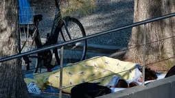 Warga menggunakan selimut tidur di taman bermain setelah gempa bumi 6,5 SR melanda Pulau Kos, Yunani, Sabtu (22/7). Gempa membuat warga memilih tidur di luar rumah karena takut gempa susulan. (AFP Photo/Louissa Gouliamaki) 