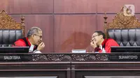 Ketua Mahkamah Konstitusi (MK) Suhartoyo (kanan) berbicara dengan Hakim Konstitusi Saldi Isra (kiri) di sela sidang perkara Nomor 145/PUU-XXI/2023 di Gedung MK, Jakarta, Selasa (16/1/2024). (Liputan6.com/Angga Yuniar)