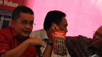 Ketua DPP bidang hukum PDIP Trimedya Panjaitan (kiri) menunjukkan buku 'Bersama Jokowi Mengawal Penegakan Hukum', Jakarta, Selasa (30/12/2014). (Liputan6.com/Faizal Fanani)