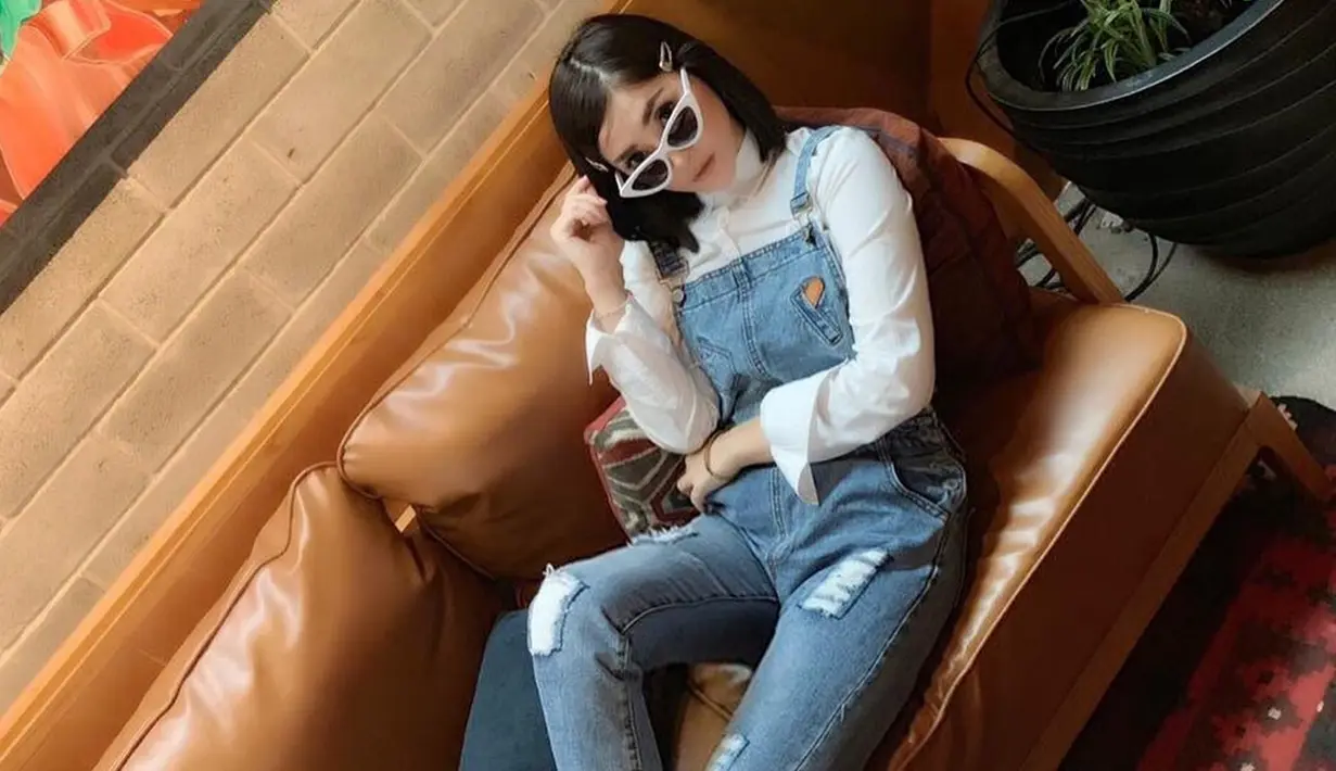 Tampilan wanita 34 tahun ini terlihat bak anak muda. Ia memadukan sebuah jumpsuit denim dengan baju berwarna putih. Kacamata yang digunakan pun terlihat serasi dengan penampilannya ini. (Liputan6.com/IG/@eva_anindita_zachrie)