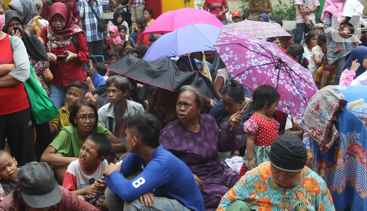 Pengemis menunggu sedekah Imlek di halaman Vihara Dharma Bhakti, Petak Sembilan, Jakarta Barat, Sabtu (25/1/2020). Pembagian sedekah tersebut dalam rangka berbagi dengan sesama ketika perayaaan Tahun Baru Imlek 2571. (Liputan6.com/Angga Yuniar)