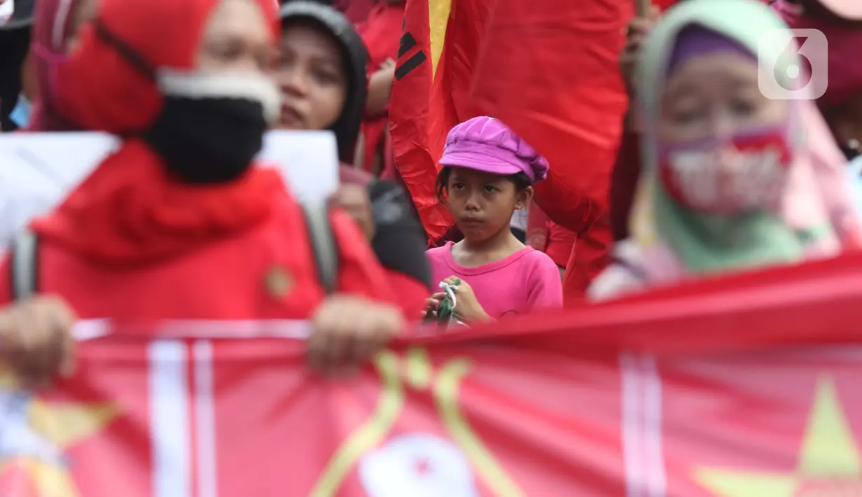 Seorang anak terlihat dalam aksi unjuk rasa menolak pengesahan UU Omnibus Law Cipta Kerja di Kawasan Patung Kuda, Jakarta, Jumat (16/10/2020). Meski sudah ada imbauan untuk tidak membawa anak-anak dalam aksi unjuk rasa namun sejumlah orang tua tetap menyertakan. (Liputan6.com/Helmi Fithriansyah)