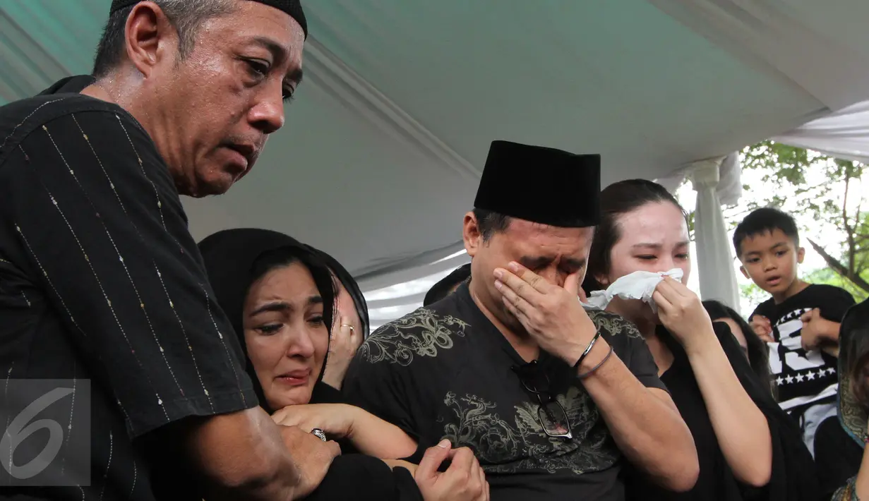 Penyanyi Ashanty didampangi suaminya, Anang Hermansyah terlihat menangis selama prosesi pemakaman sang ibunda, Ratu Farida, di TPU Jeruk Purut, Jakarta, Senin (7/11). Ibunda Ashanty meninggal dunia di usia 72 tahun. (Liputan6.com/Herman Zakharia)