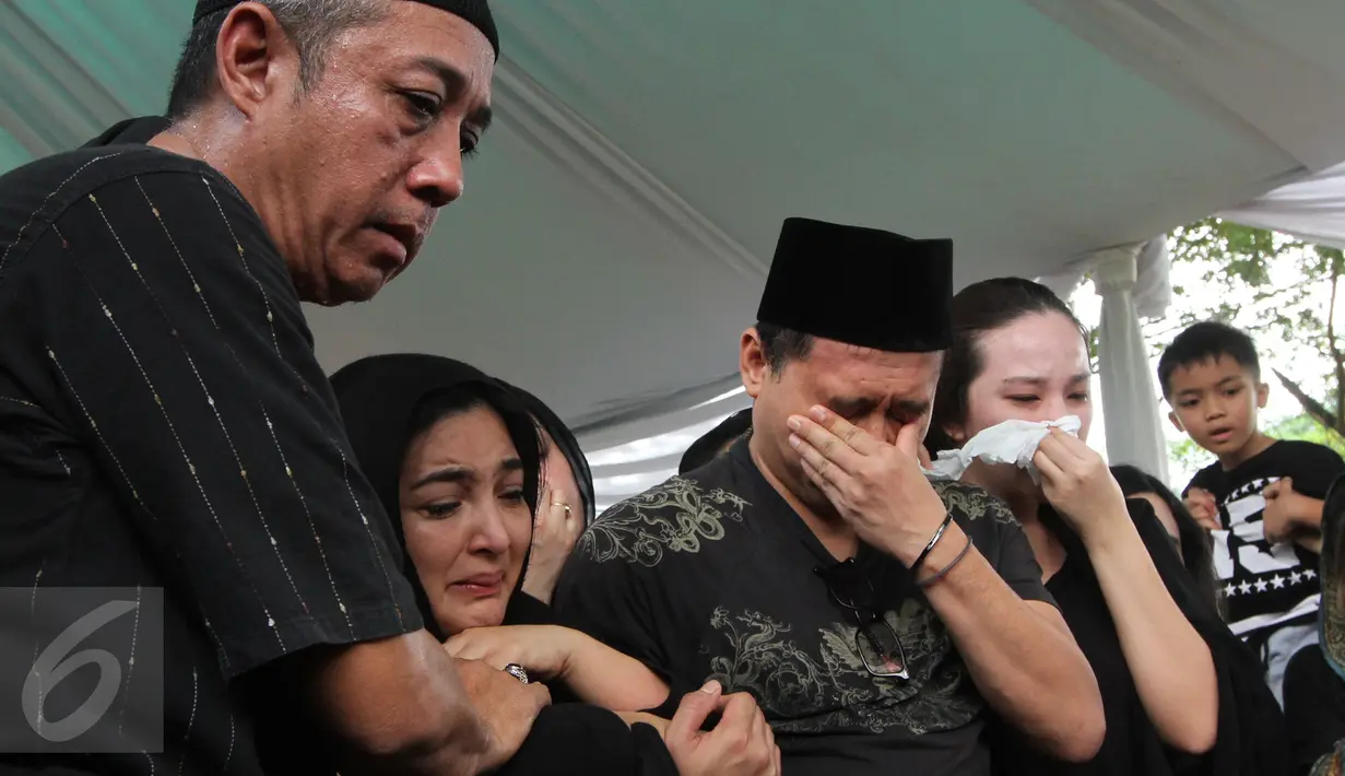 Penyanyi Ashanty didampangi suaminya, Anang Hermansyah terlihat menangis selama prosesi pemakaman sang ibunda, Ratu Farida, di TPU Jeruk Purut, Jakarta, Senin (7/11). Ibunda Ashanty meninggal dunia di usia 72 tahun. (Liputan6.com/Herman Zakharia)
