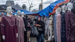 Pemerintah juga akan memberantas praktik thrifting illegal. Tampak dalam foto, pembeli berjalan di antara kios-kios penjual pakaian lokal di salah satu pasar tradisional, Jakarta, Kamis 20 November 2025. (BAY ISMOYO/AFP)
