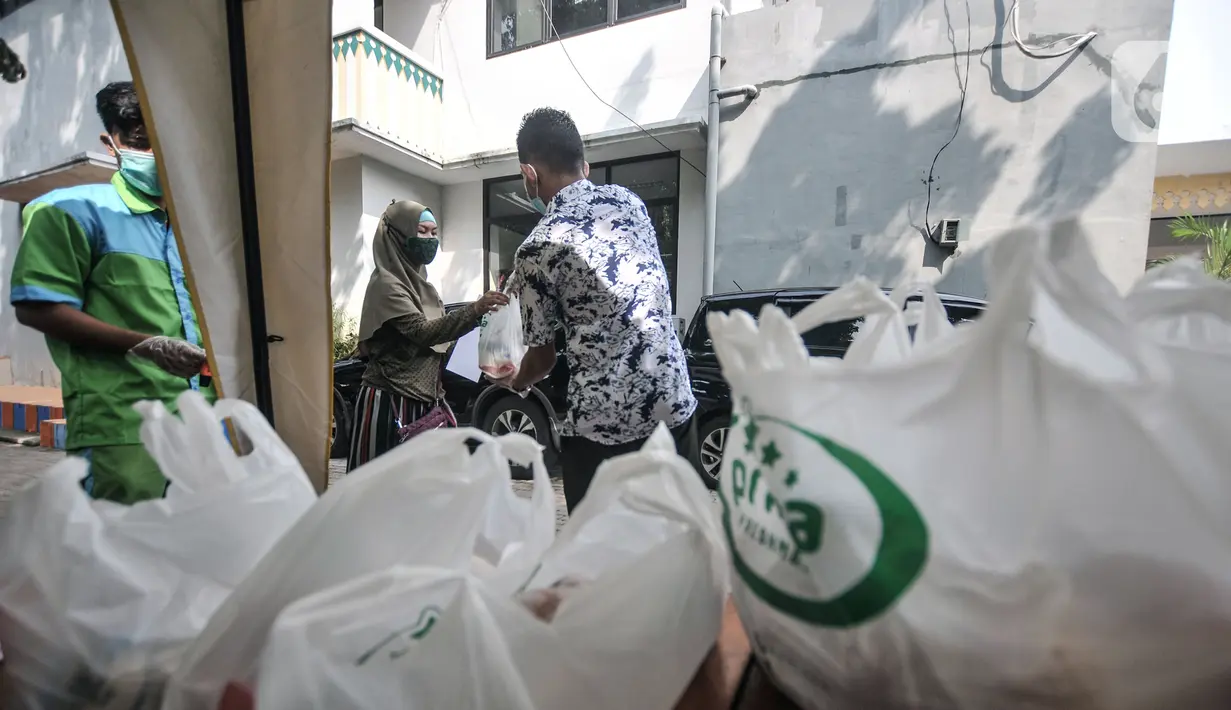 Warga menerima sembako usai mengikuti vaksinasi COVID-19 di Kantor Kelurahan Ancol, Jakarta, Kamis (17/6/2021). LMK Kelurahan Ancol menargetkan vaksinasi COVID-19 dapat diterima oleh 400 orang per hari. (merdeka.com/Iqbal S. Nugroho)