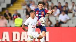 Pemain Barcelona, Robert Lewandowski (kanan) berebut bola dengan pemain Tottenham Hotspur, Pedro Porro pada laga Piala Joan Gamper edisi ke-58 di Estadi Olimpic Lluis Companys, Barcelona, 8 Agustus 2023. (AFP/Pau Barrena)