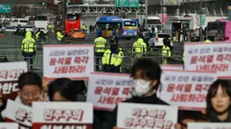 Dengan penjagaan ketat pihak kepolisian setempat, pengunjuk rasa turun ke jalan untuk menuntut mundur Presiden Korea Selatan Yoon Suk Yeol pasca-pencabutan status darurat militer. (ANTHONY WALLACE/AFP)