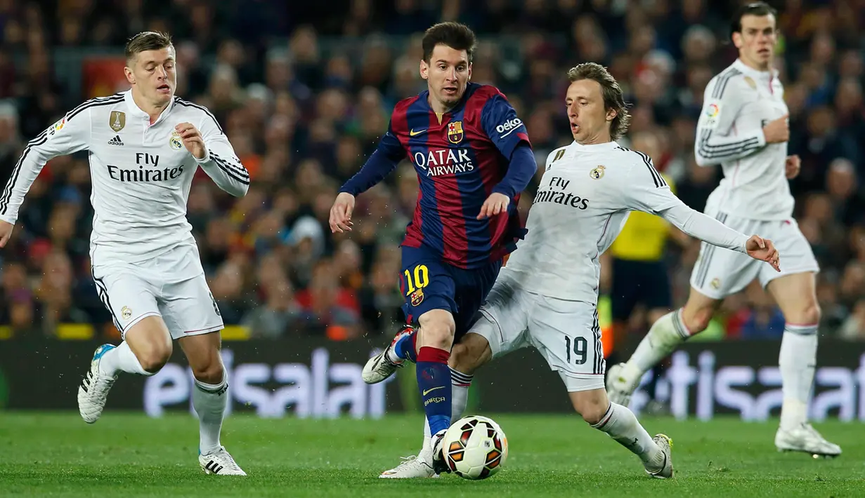 Penyerang Barcelona, Lionel Messi (kedua dari kiri) berusaha melewati dua pemain Real Madrid pada laga Liga Spanyol di Stadion Nou Camp, Senin (23/3/2015). Barcelona Menang 2-1 atas Real Madrid. (Reuters/Albert Gea)