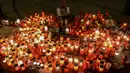 Ratusan lilin dinyalakan di depan foto jurnalis investigasi Slovakia Jan Kuciak di Wenceslas Square di Praha (26/2). Sebelumnya Jan Kuciak dan kekasihnya ditemukan tewas ditembak di rumah yang mereka tempati. (AFP Photo/Michal Cizek)