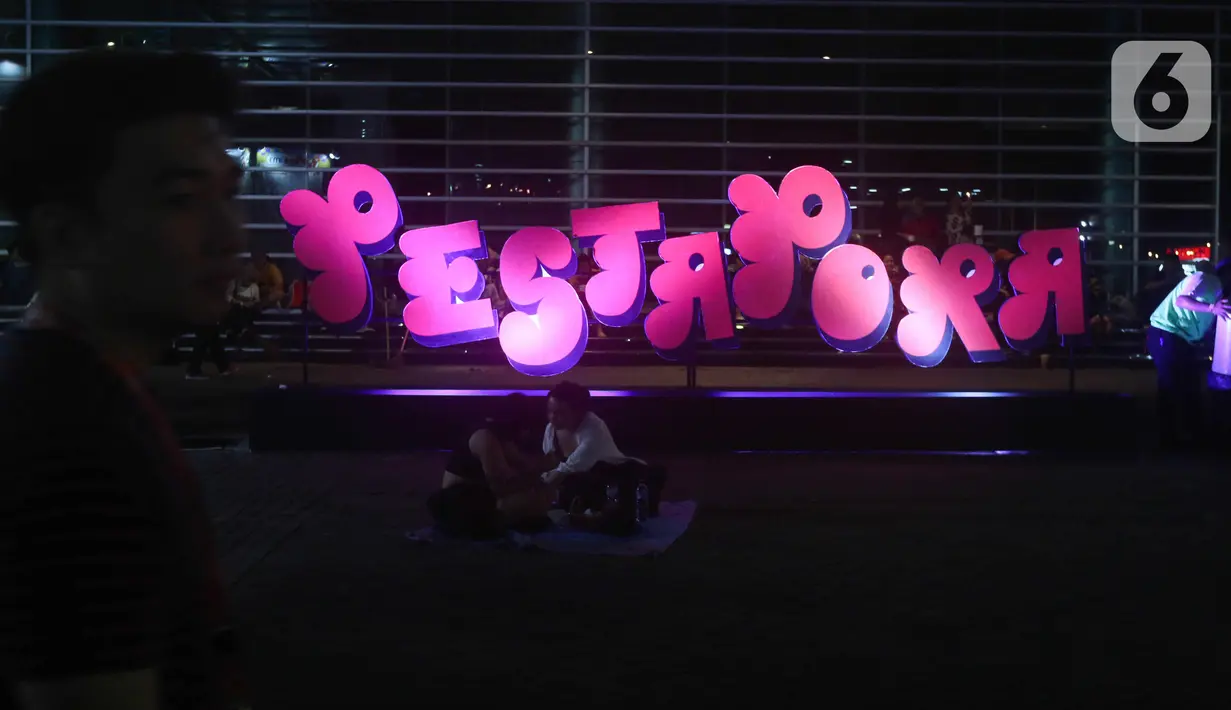 Sejumlah pengunjung duduk di bangunan instalasi pada acara "Pestapora 2022" di Gambir Expo Kemayoran, Jakarta, Sabtu (24/9/2022). Pada acara pertunjukan musik Indonesia yang berlangsung 23-25 September 2022 tersebut menghadirkan enam panggung pertunjukan dengan menampilkan berbagai musisi tanah air. (Liputan6.com/Herman Zakharia)