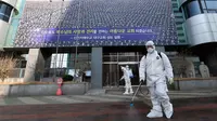 Petugas menyemprotkan disinfektan di depan Gereja Shincheonji di Daegu, Korea Selatan, Kamis (20/2/2020). Korea Selatan resmi menjadi negara terbesar yang melaporkan jumlah kasus virus corona atau COVID-19 di luar China. (Kim Jun-beom/Yonhap via AP)